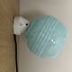 Wall light in ceramic with a light blue glass globe.