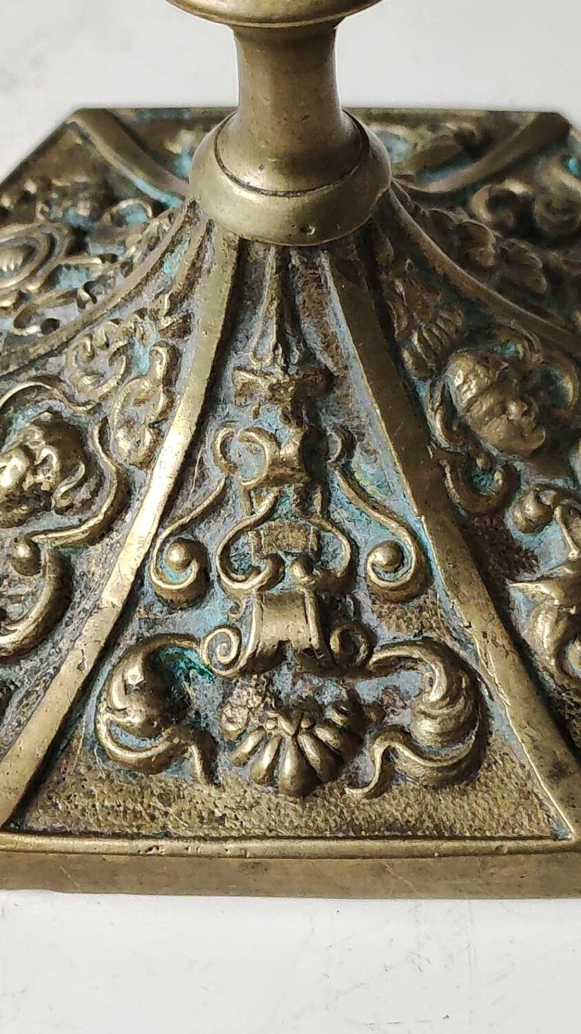 Baroque/Antique style torch candleholder, nineteenth, gilded bronze. Head motifs, volute arabesques