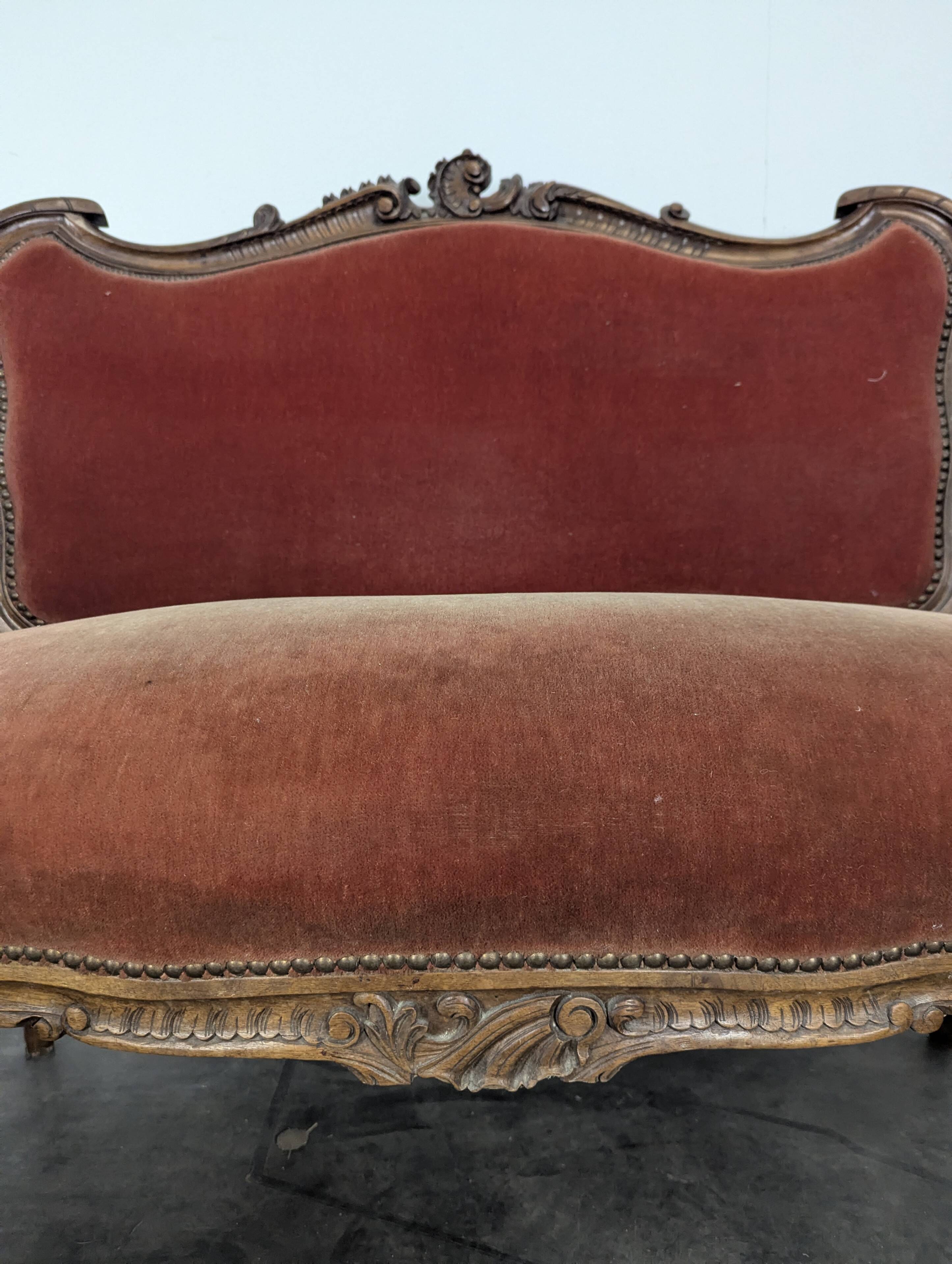Louis XV style salon in carved walnut with orange velvet, seven pieces.