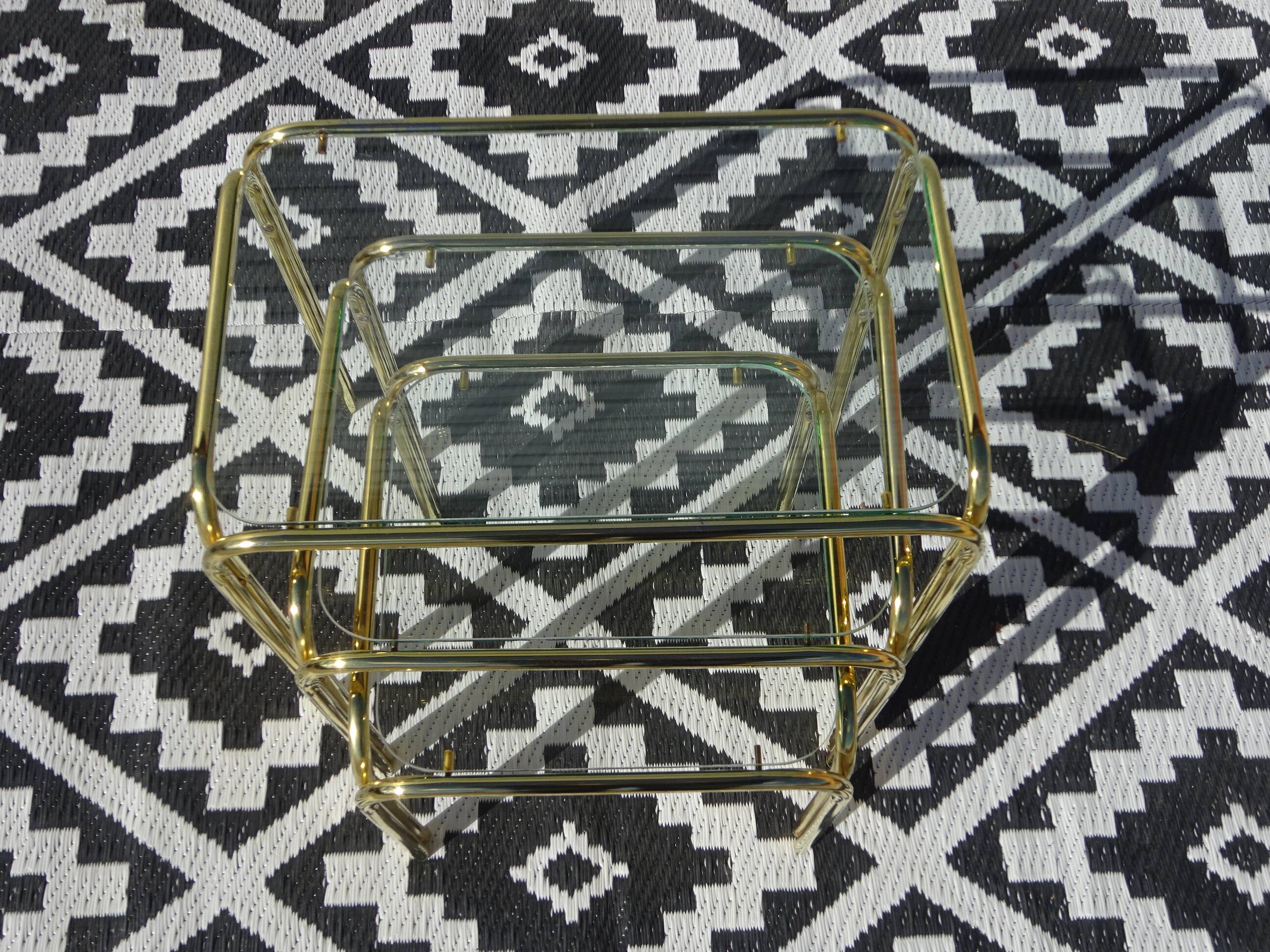 Nested tubular tables in gold metal.