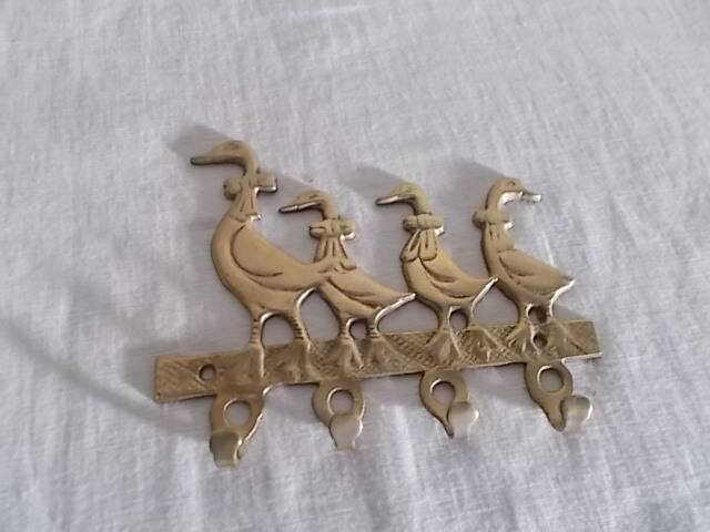 Wall-mounted tea towel holder or key holder in brass with ducks.