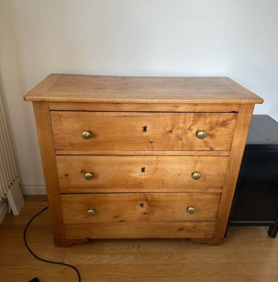 Rustic English pine chest of drawers with porcelain knobs.