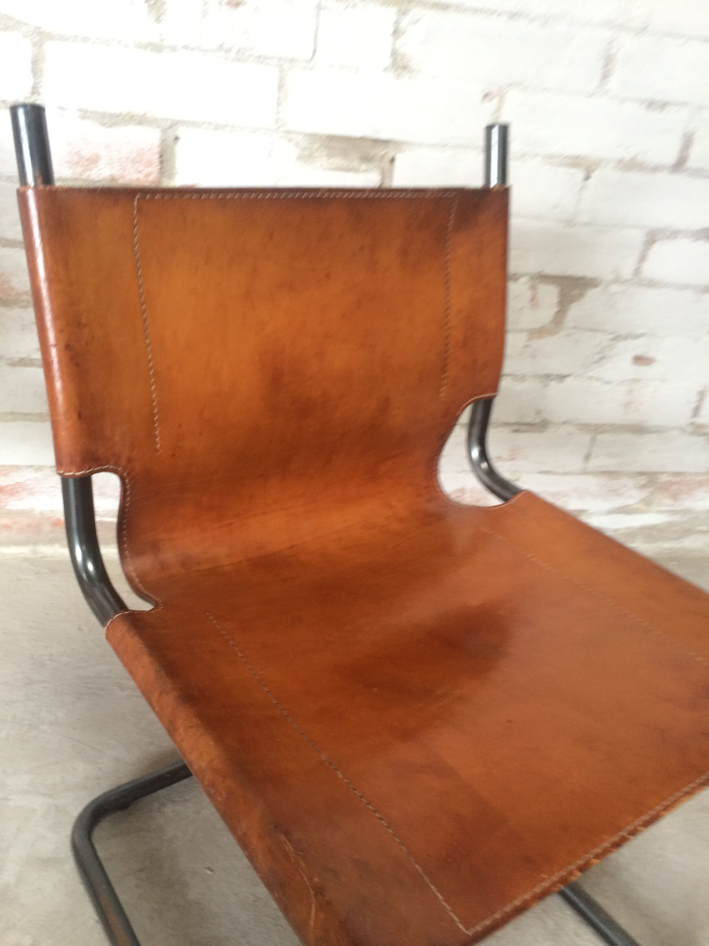 pair of tubular chairs in tawny leather