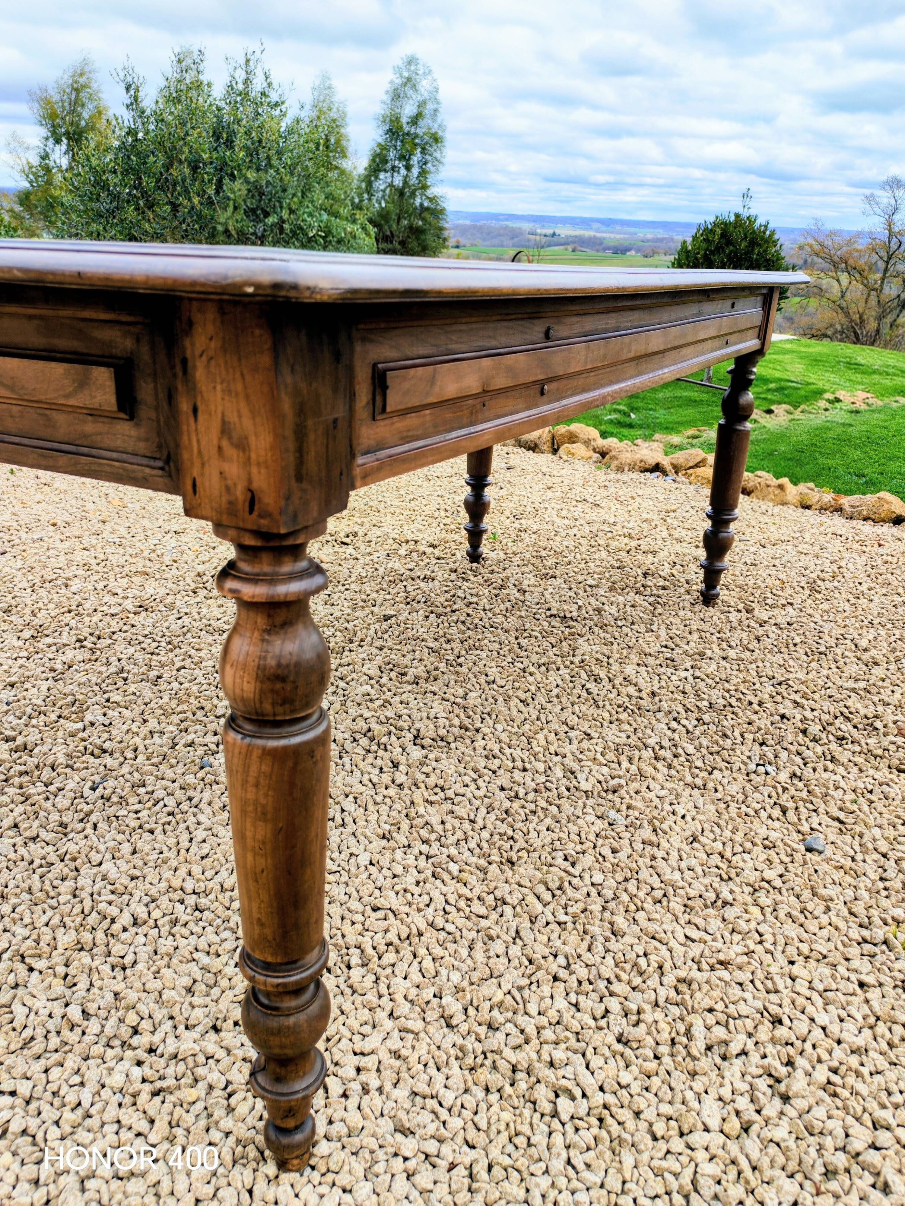Old French farmhouse table in walnut with turned legs.