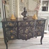 Large black chest of drawers with golden floral decoration