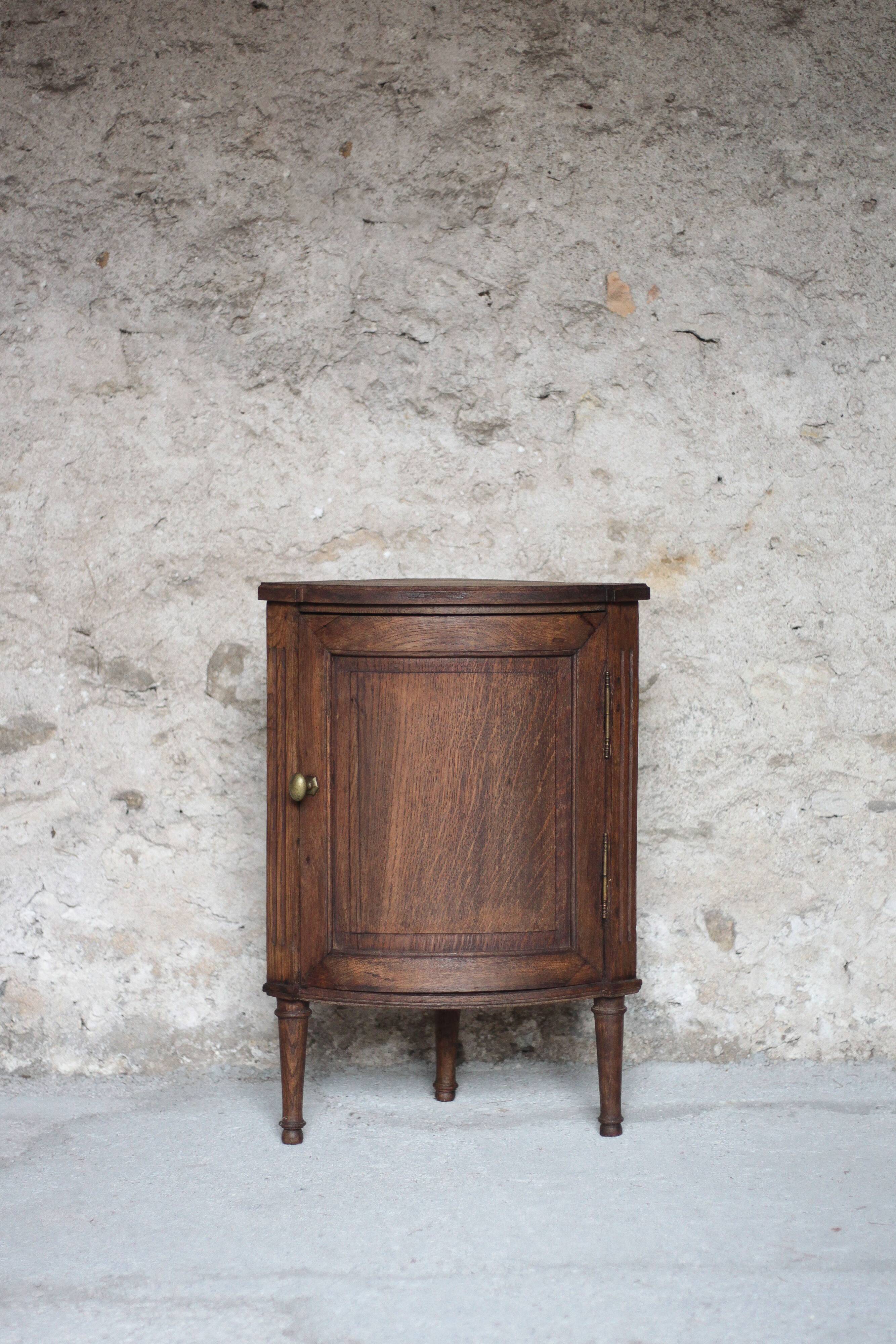 Antique wooden corner cabinet with a curved door.