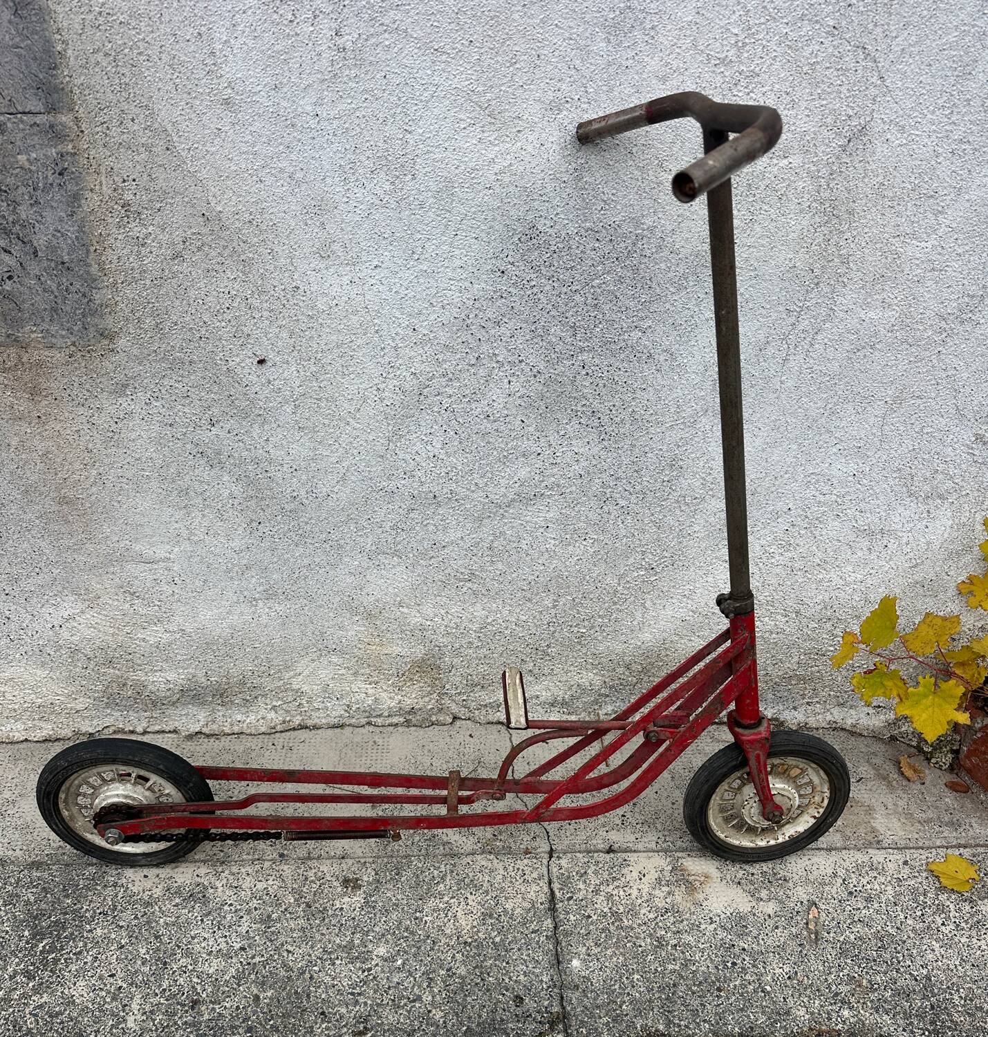 Trottinette rouge ancienne à pédale et chaîne