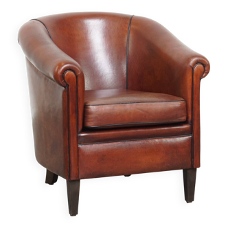 Sheepskin club armchair in a warm deep colour finished with black piping