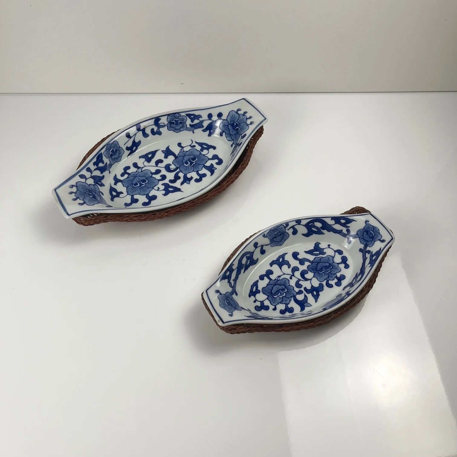 Set of 6 ceramic presentation plates in white and blue, floral pattern with woven wicker frame, 1970s/80s.