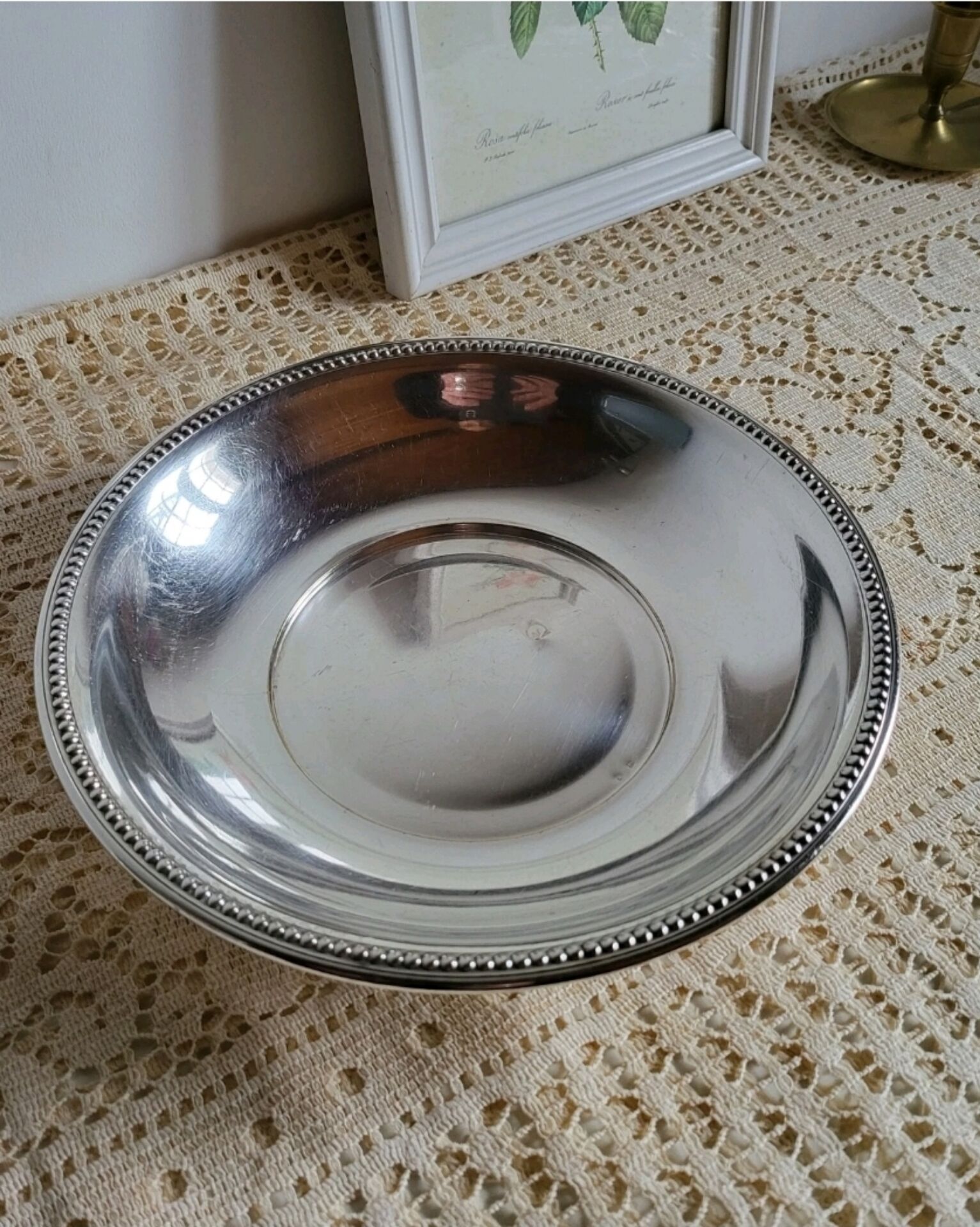 Shallow round metal plate with pearl row decoration.
