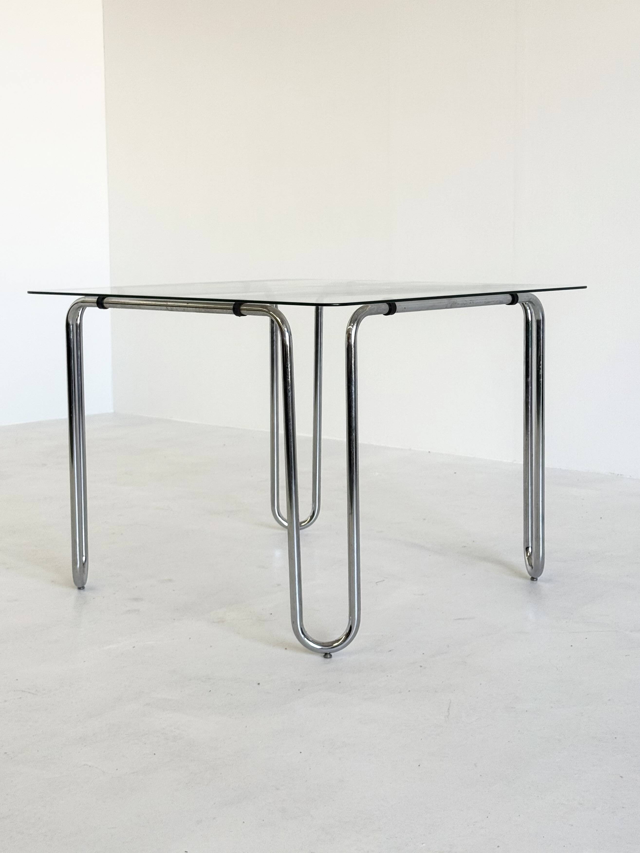 Italian vintage dining table with smooth glass and tubular frame base