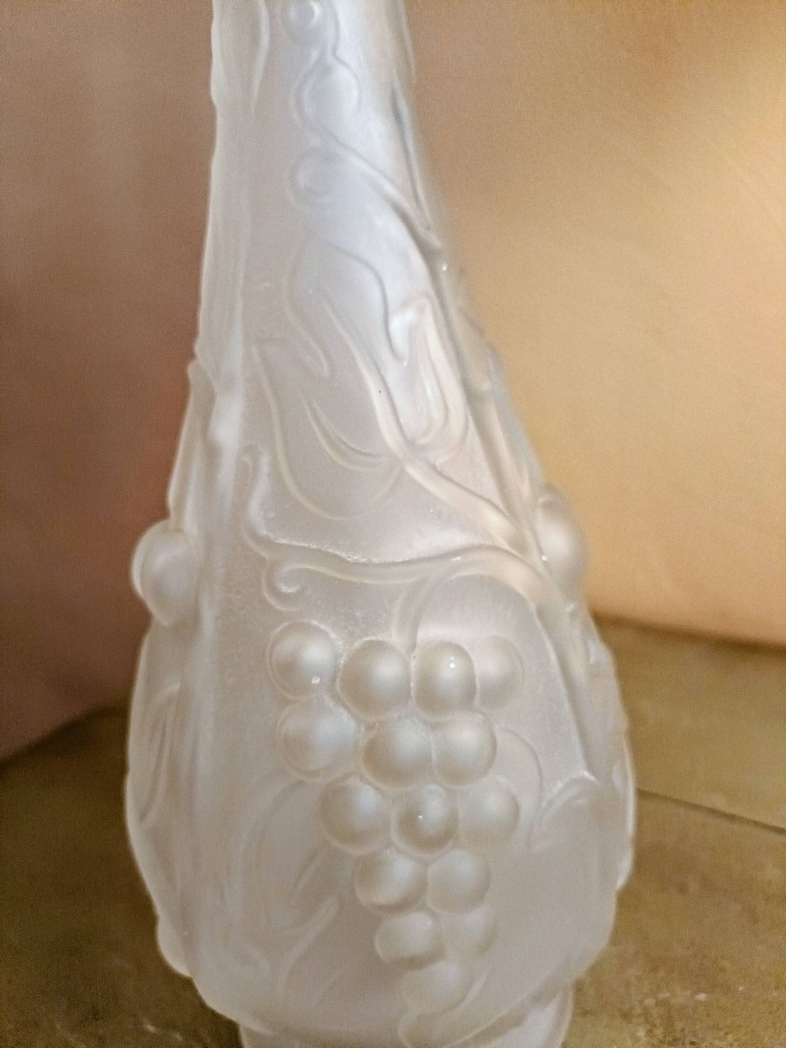 Frosted transparent glass carafe with raised cherry and grape patterns.
