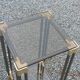 Pair of Hollywood Regency side tables in gold metal and smoked glass.