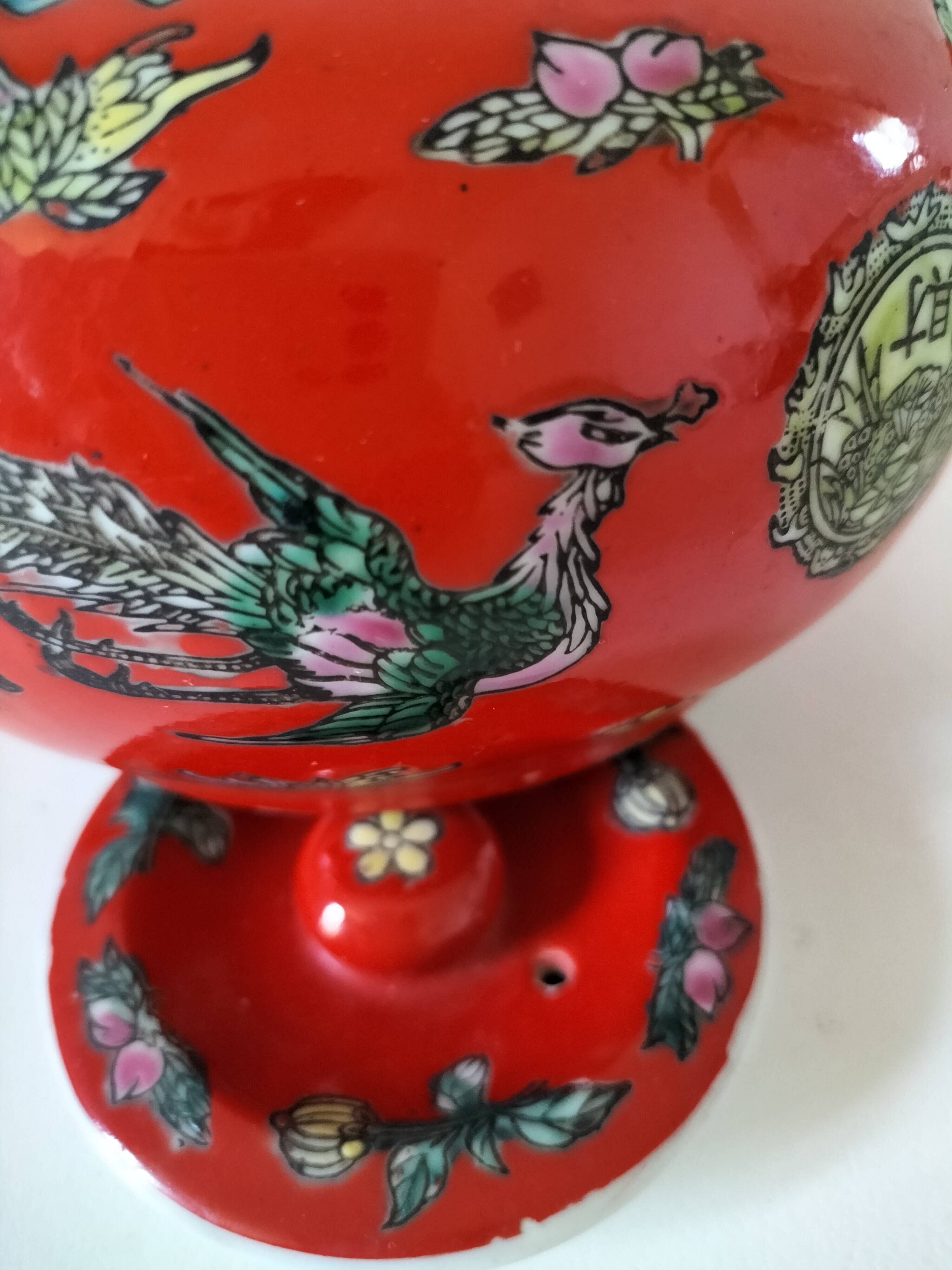 Vintage red Chinese teapot decorated with dragons and symbols.