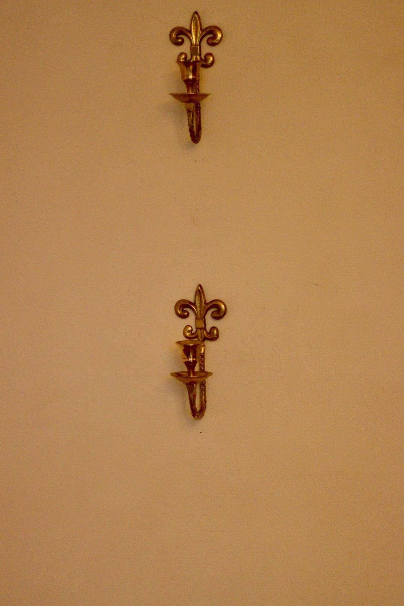 A pair of antique brass wall sconces.