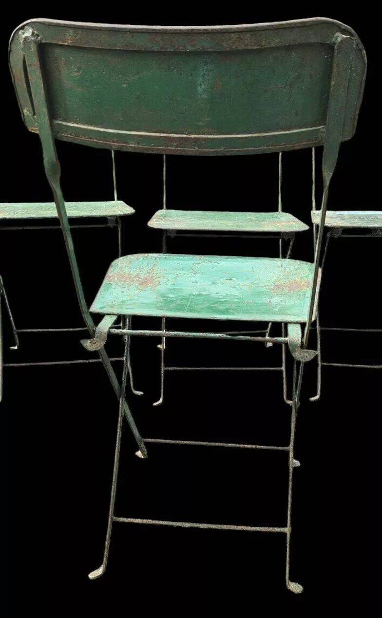 Set of 8 green painted metal industrial folding chairs.