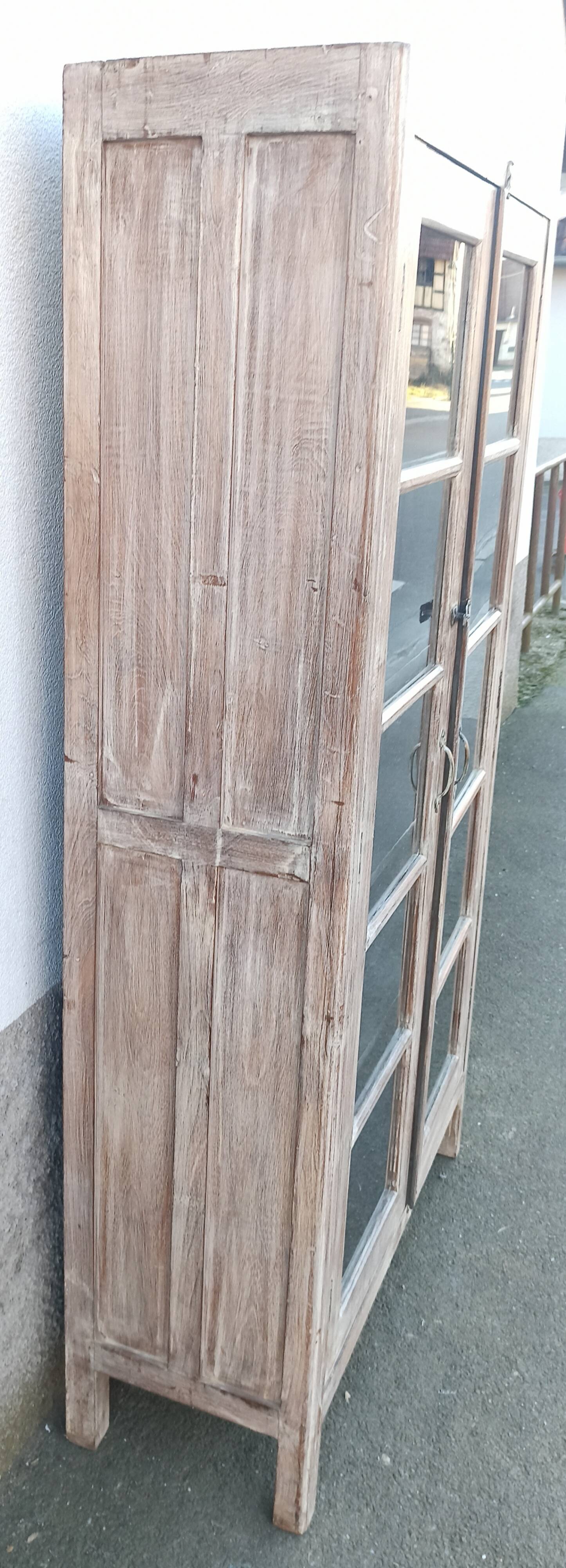 Glass cabinet in old whitewashed wood