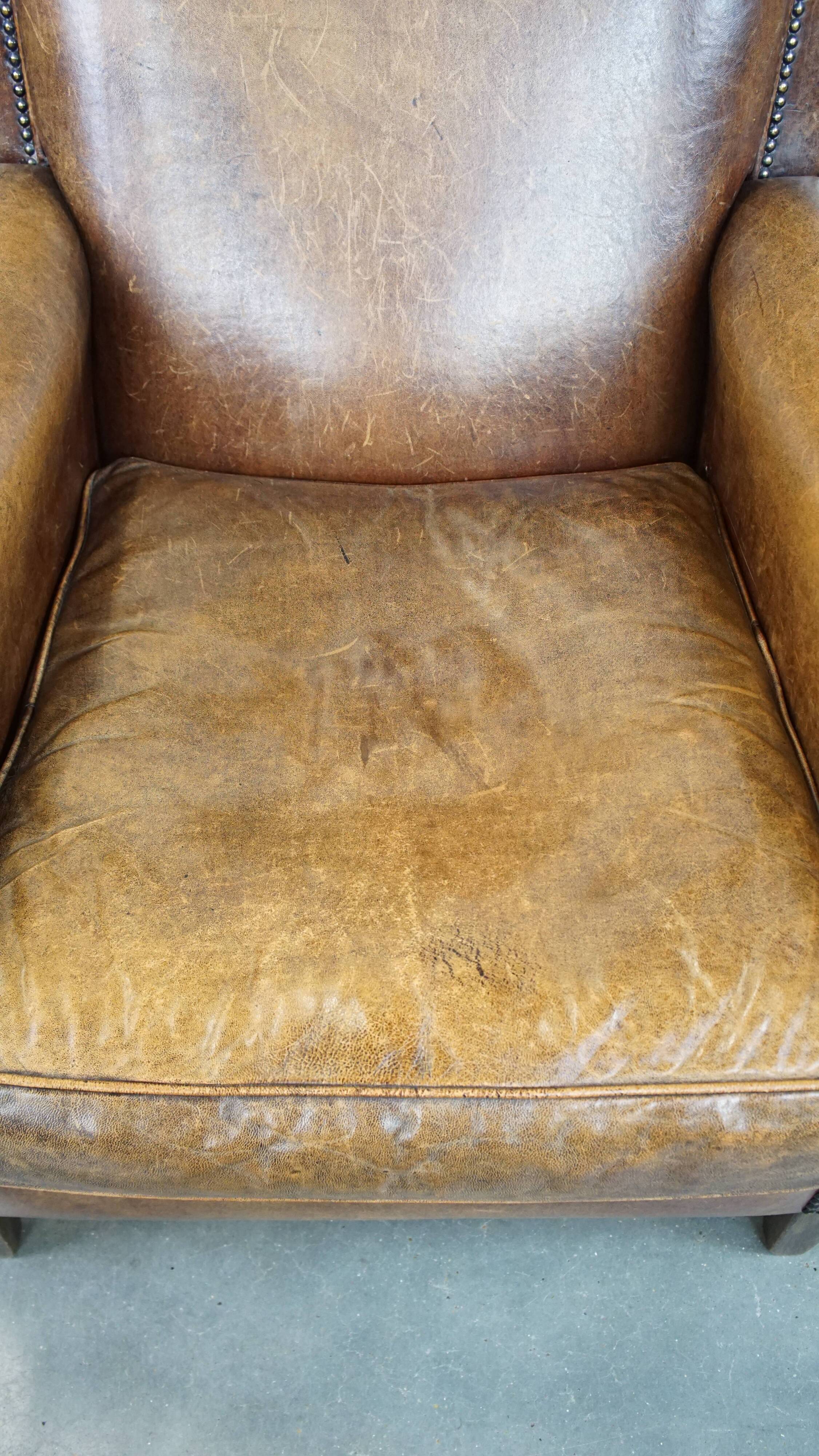 Armchair made of sheep leather finished with decorative nails