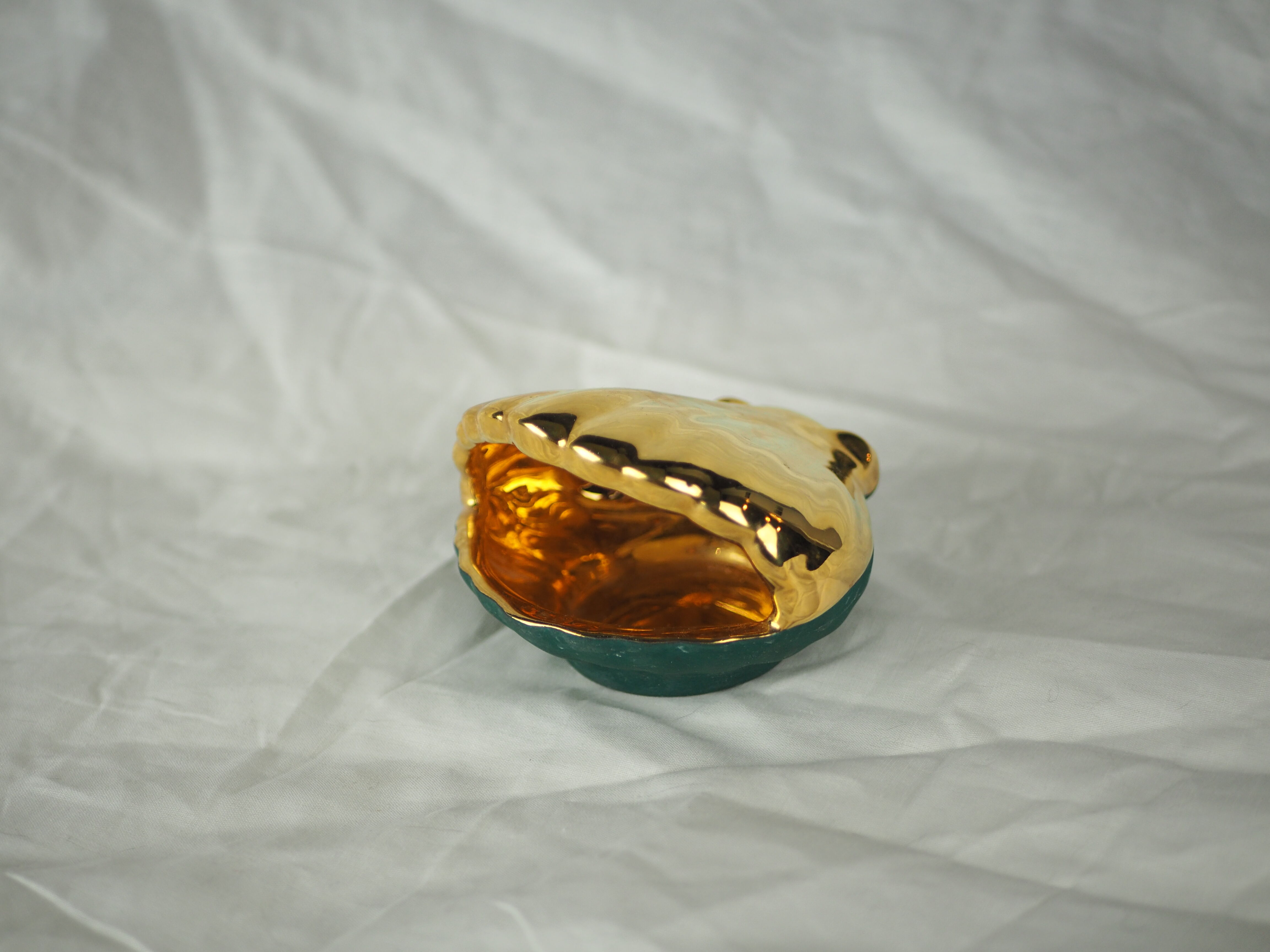 Porcelain pocket tray in the shape of a golden scallop shell with duck green background from the 50s/60s