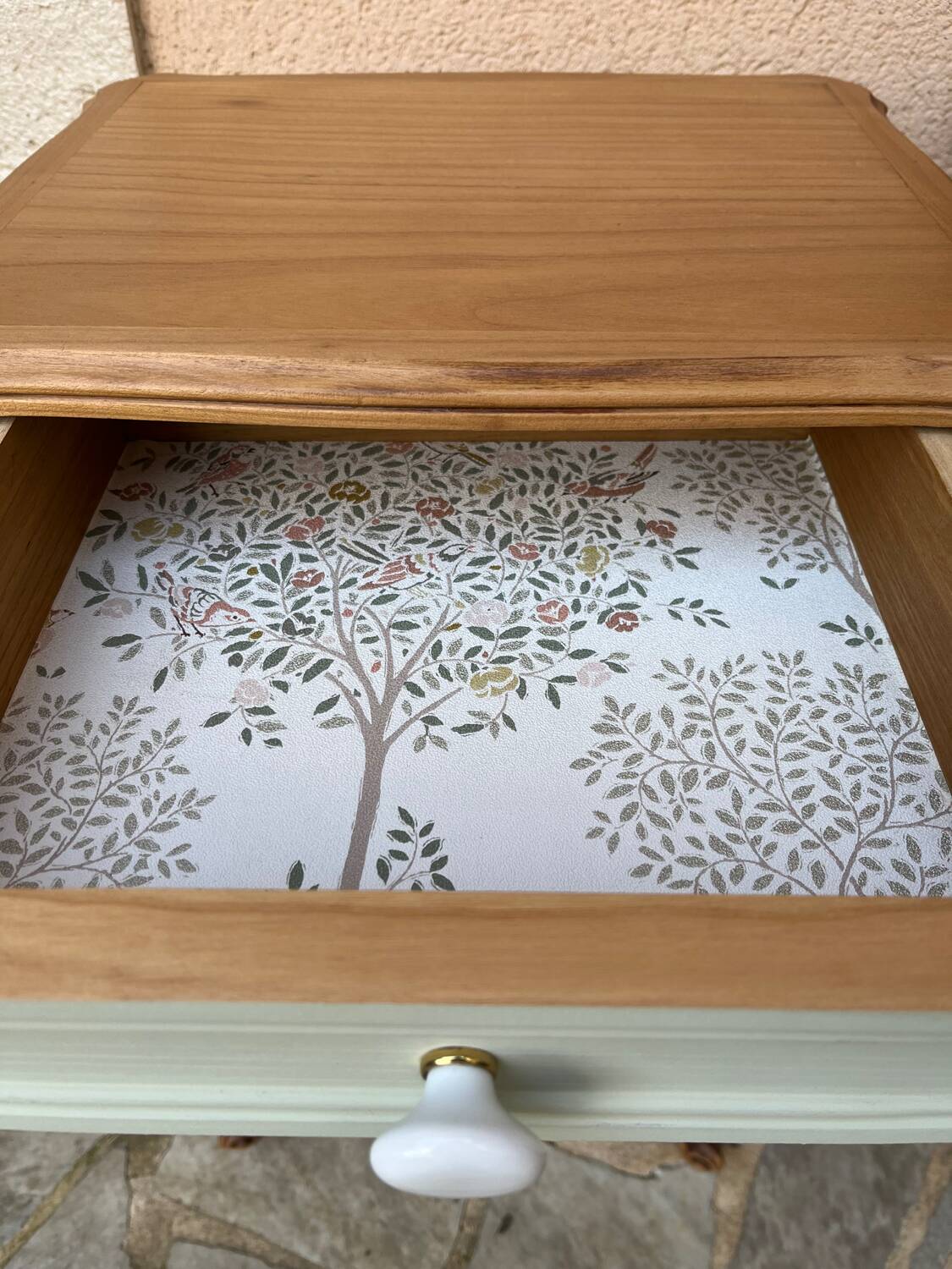 Renovated bedside tables in laurel green and light wood.