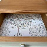 Renovated bedside tables in laurel green and light wood.