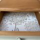 Renovated bedside tables in laurel green and light wood.