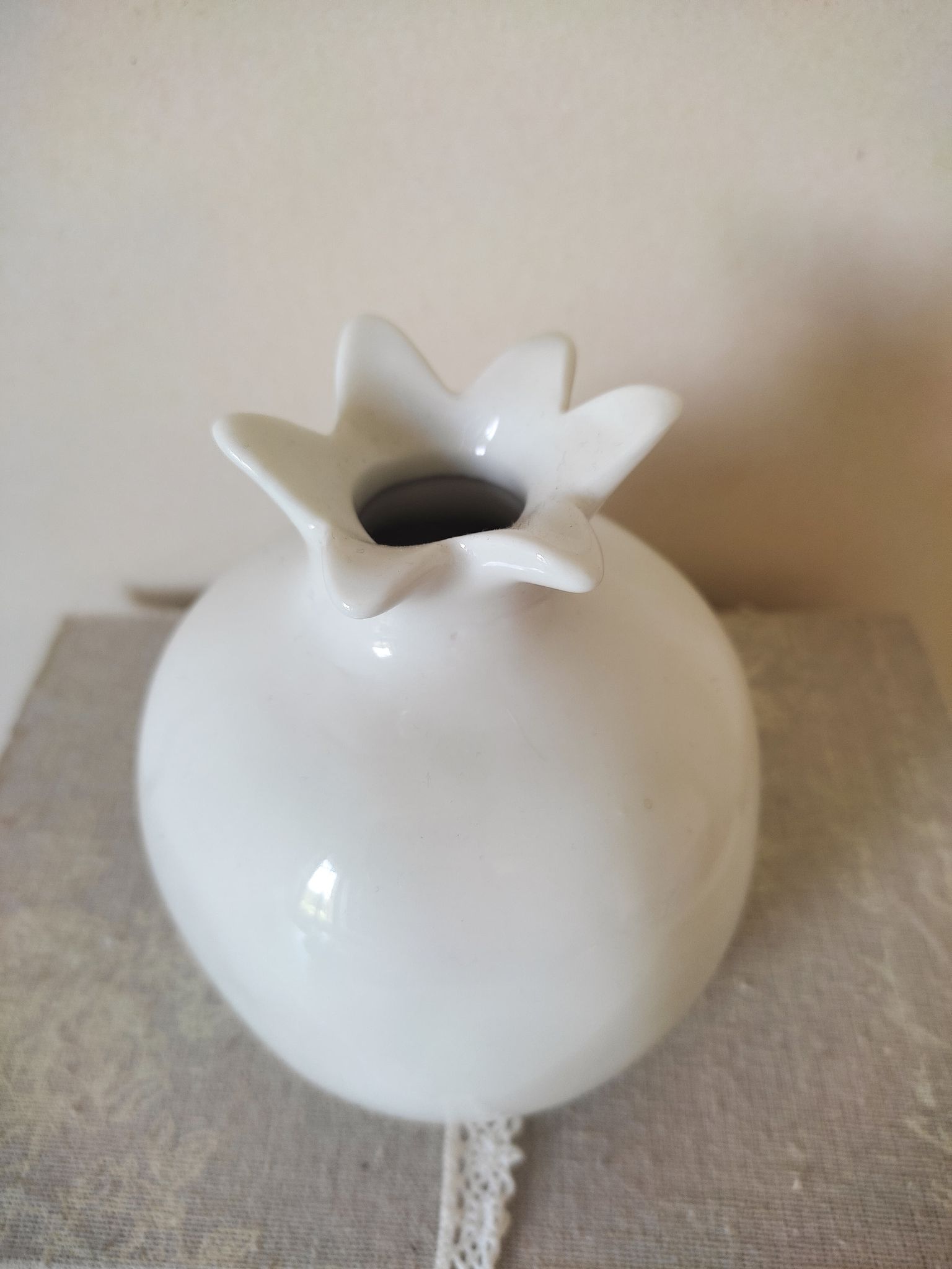 White ceramic vase in the shape of a pomegranate