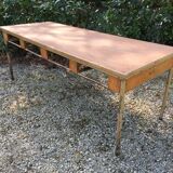 Vintage modernist table with metal tubular base and top covered with oilcloth.