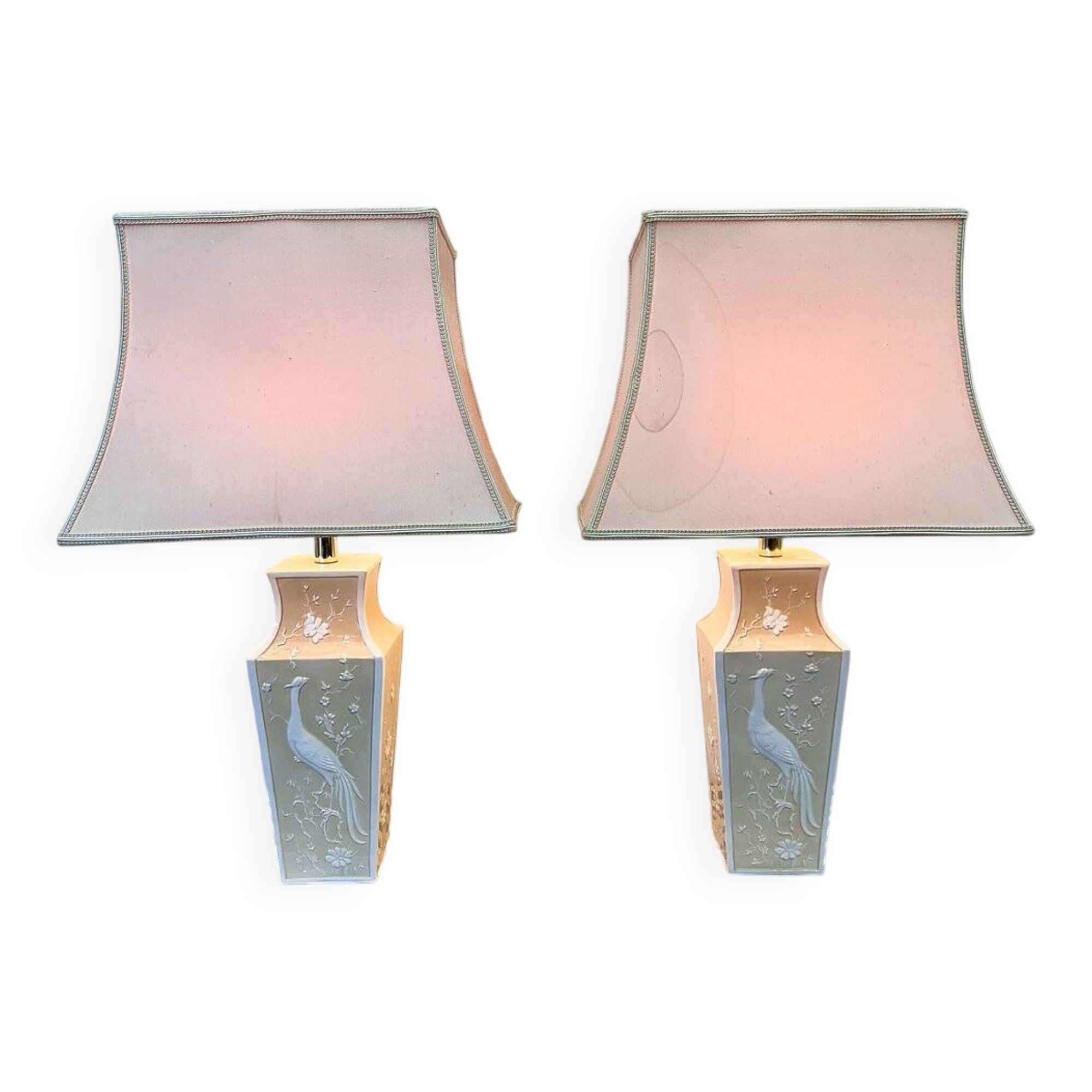 Pair of large cream ceramic table lamps with relief peacocks and fabric shades