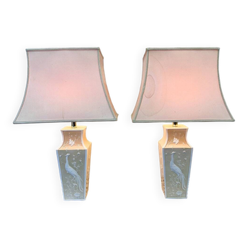 Paire de grandes lampes de table en céramique crème ornées de paons en relief et d'abat-jour en tissu.