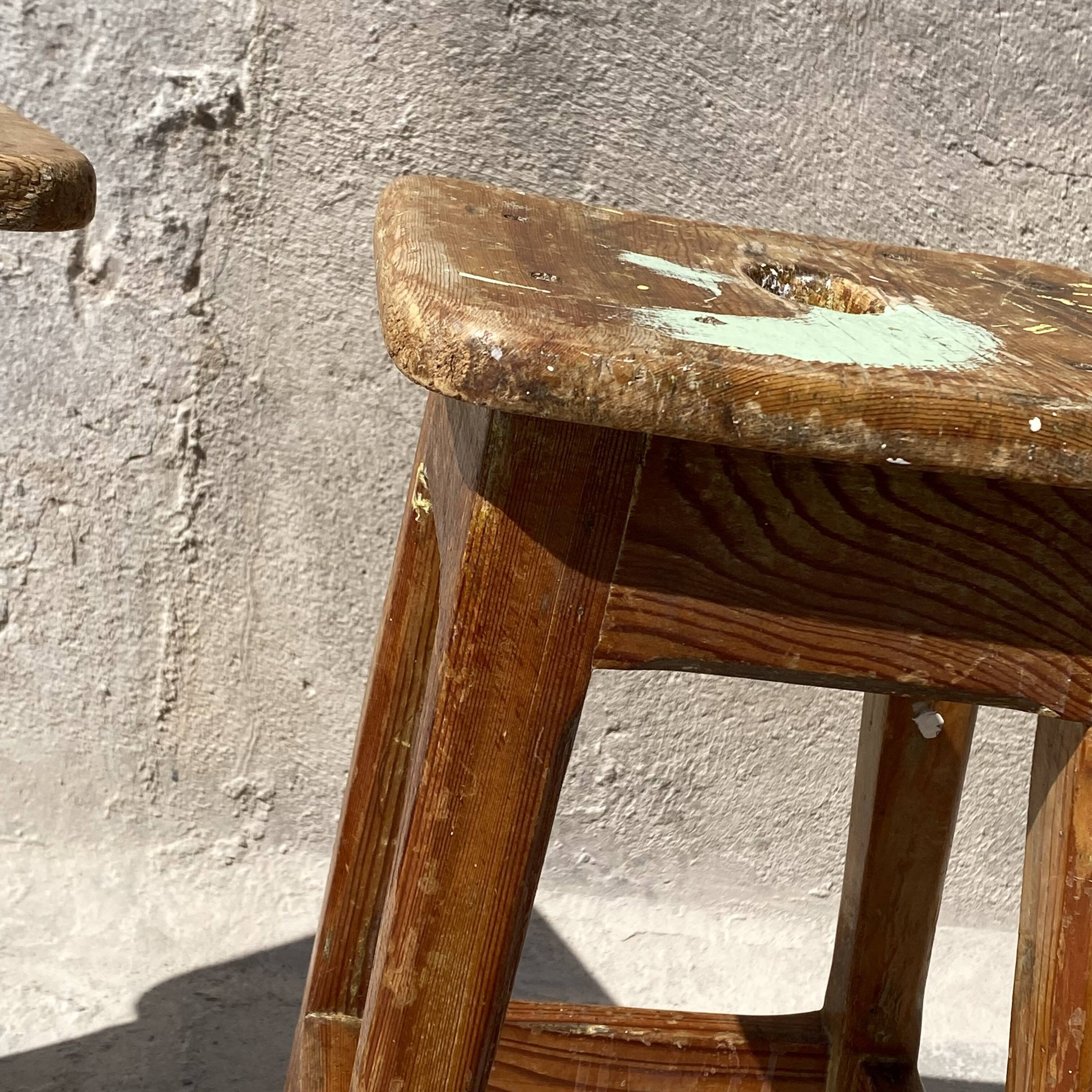 Pair of vintage wooden workshop stools with a patina.
