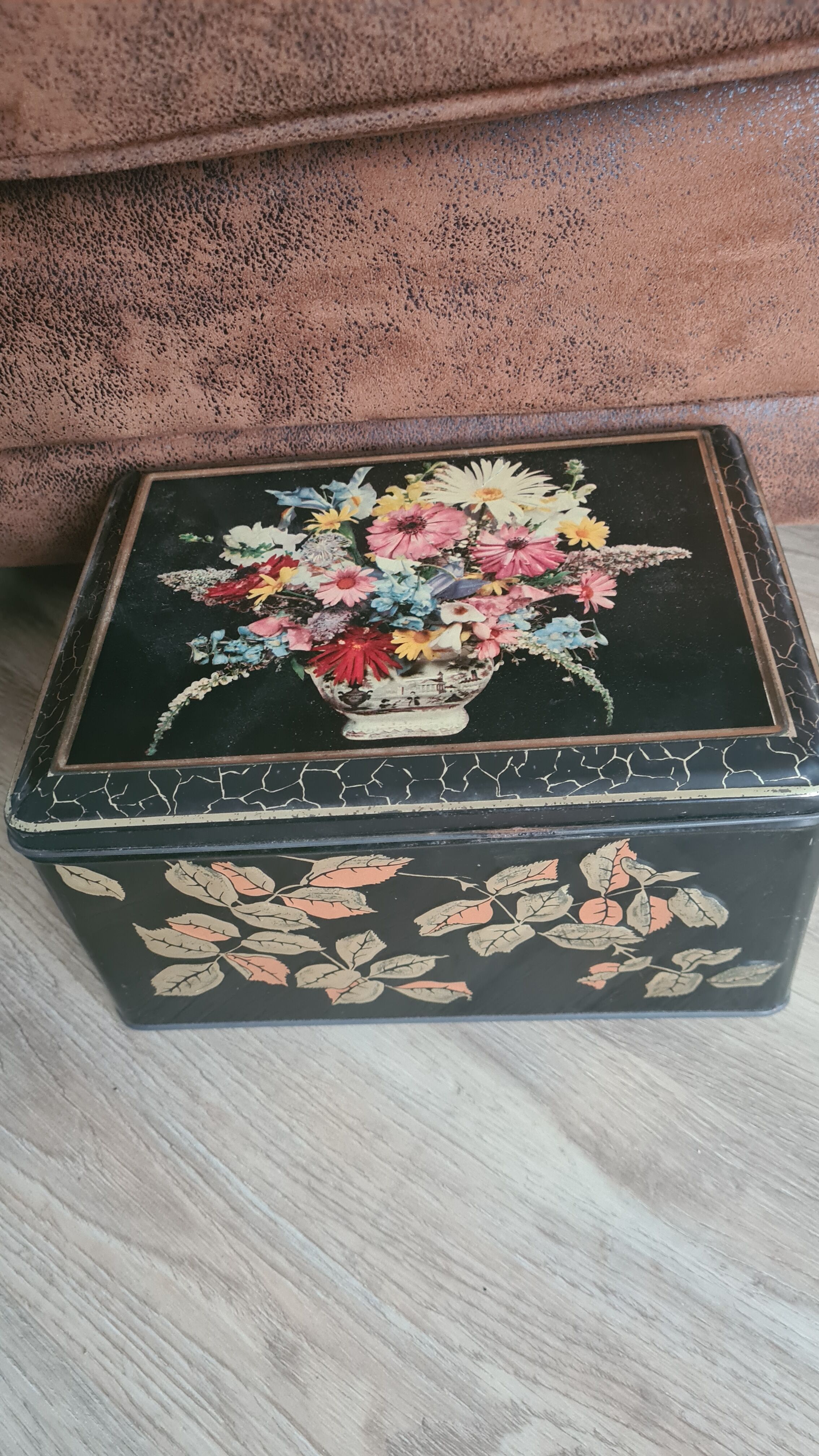 Old black metal box and flowers at the beginning of the century