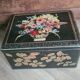 Old black metal box and flowers at the beginning of the century