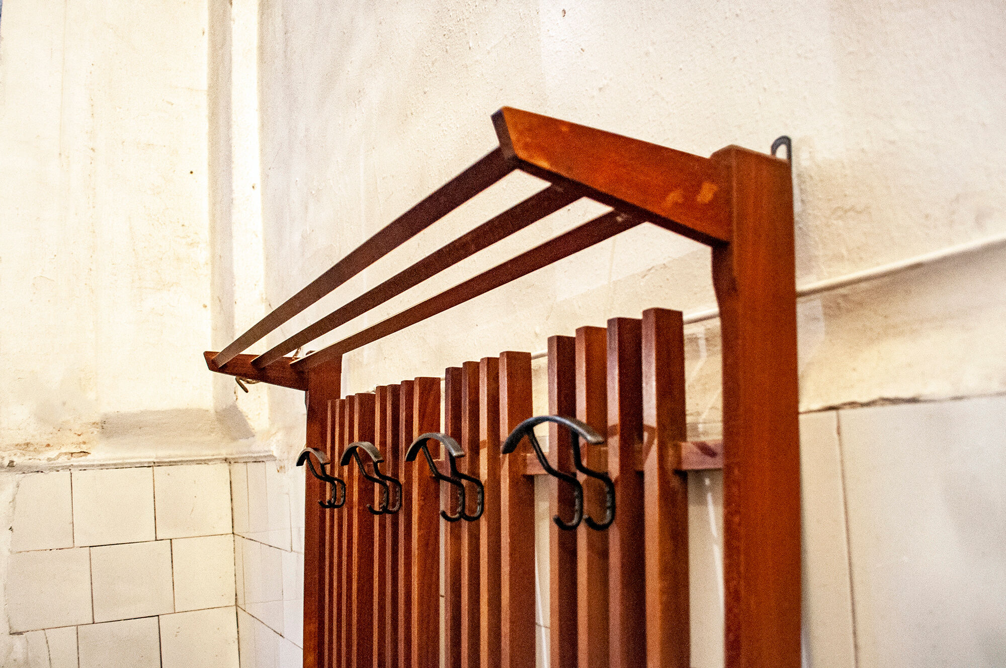 Walnut wood wall coat hangers, with metal details. Italian production 1950s