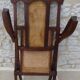 Antique folding chair with caned seat and backrest made of wood.