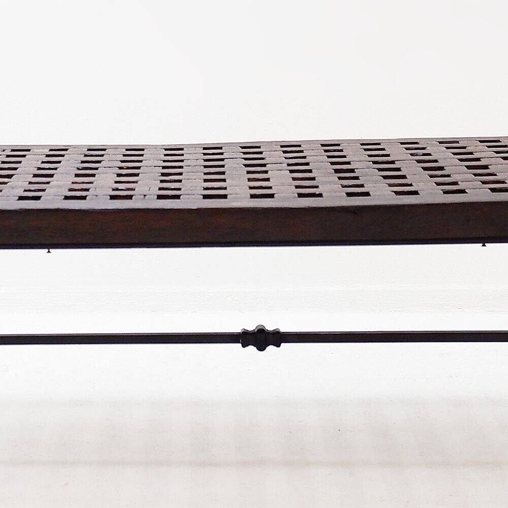 Solid wood coffee table with an openwork design and wrought iron legs.
