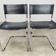 Paire de chaises cantilever simili cuir noir et chrome