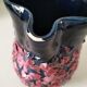 Vintage pitcher in midnight blue glazed ceramic with bright pink relief