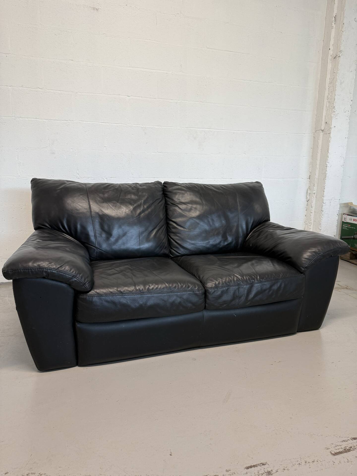 Two-seater black leather sofa — postmodern design