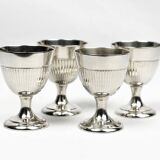 Four silver-plated Christofle egg cups with fluted sides.