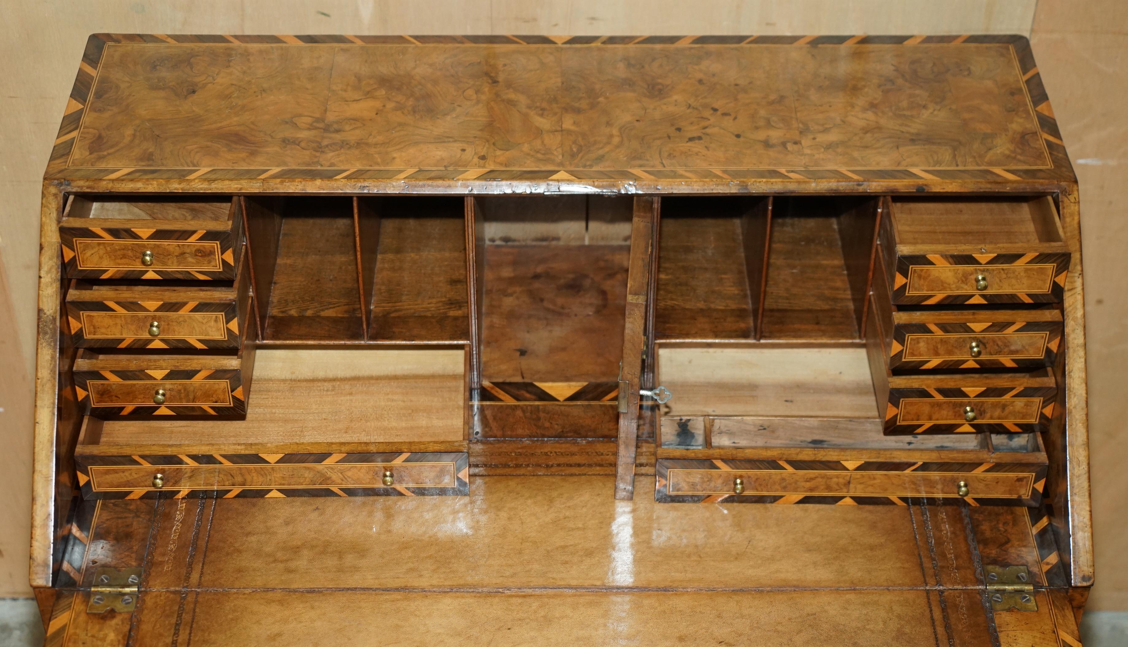 Antique George II bureau from 1740 in walnut, rosewood, and leather.