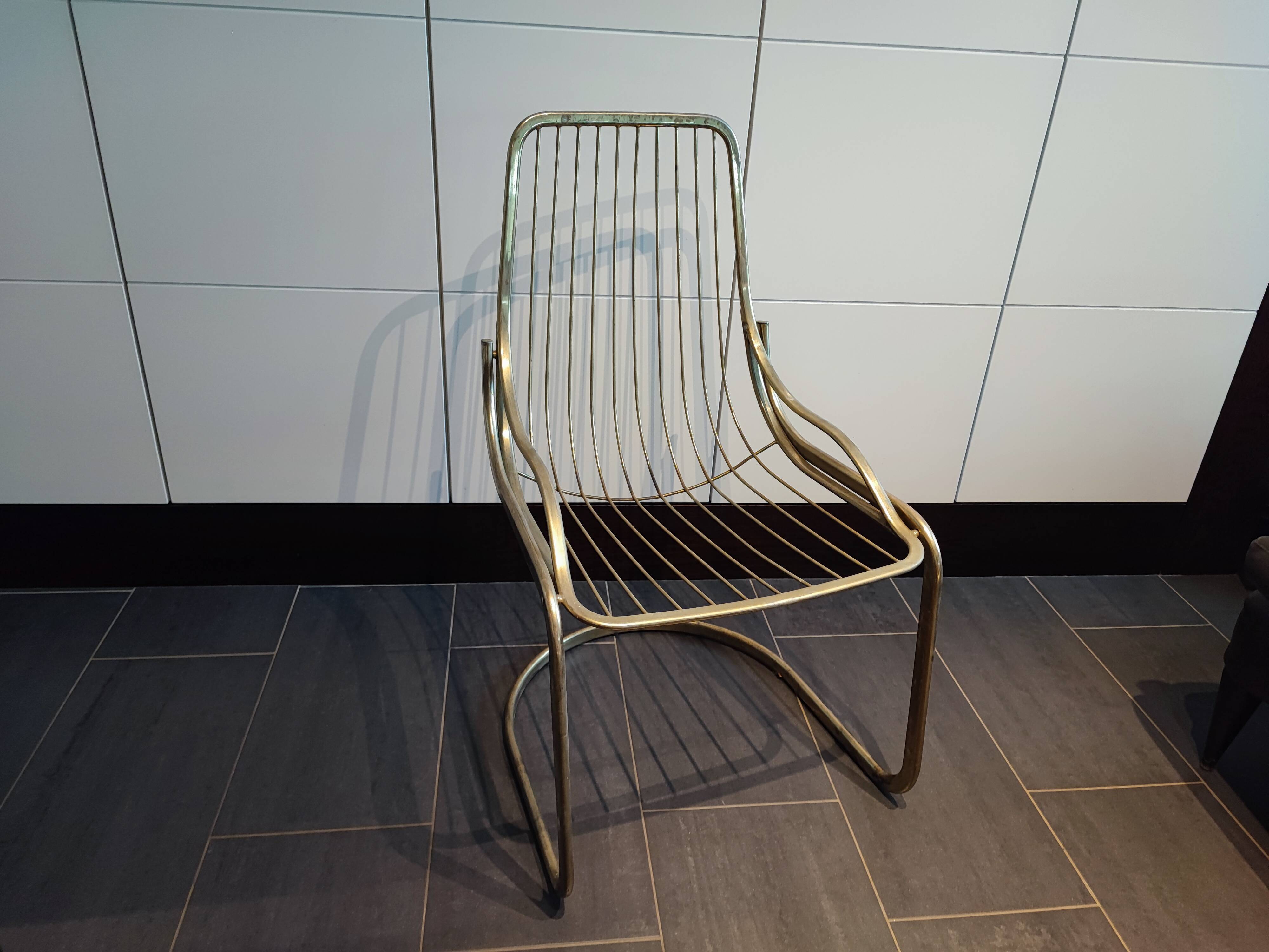 Tubular metal chair covered with gilding