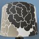 Small Space Age table lamp with a porcelain base and black and white flower shade.