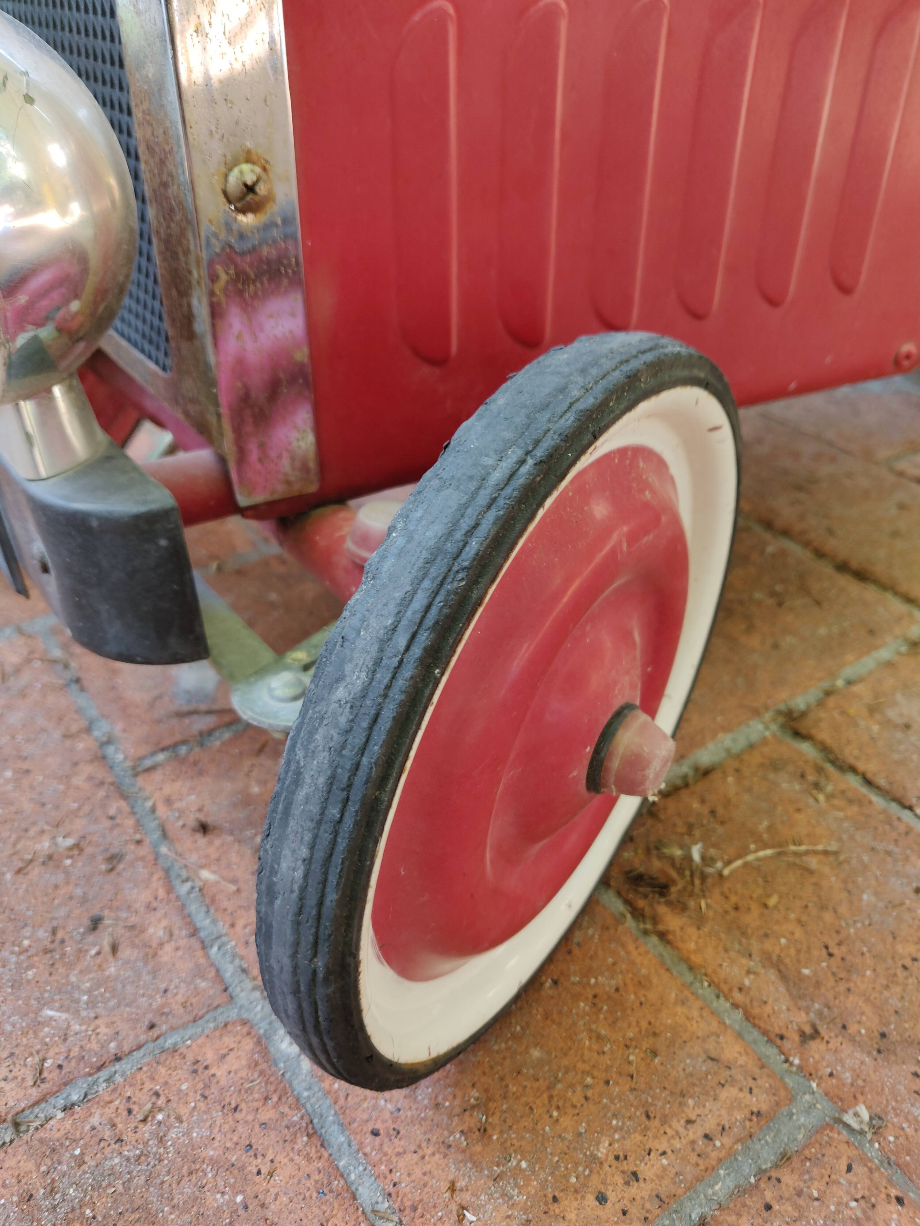 Old pedal car in tole fire truck