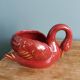 Poet Laval swan hides zoomorphic pot in burgundy ceramic.