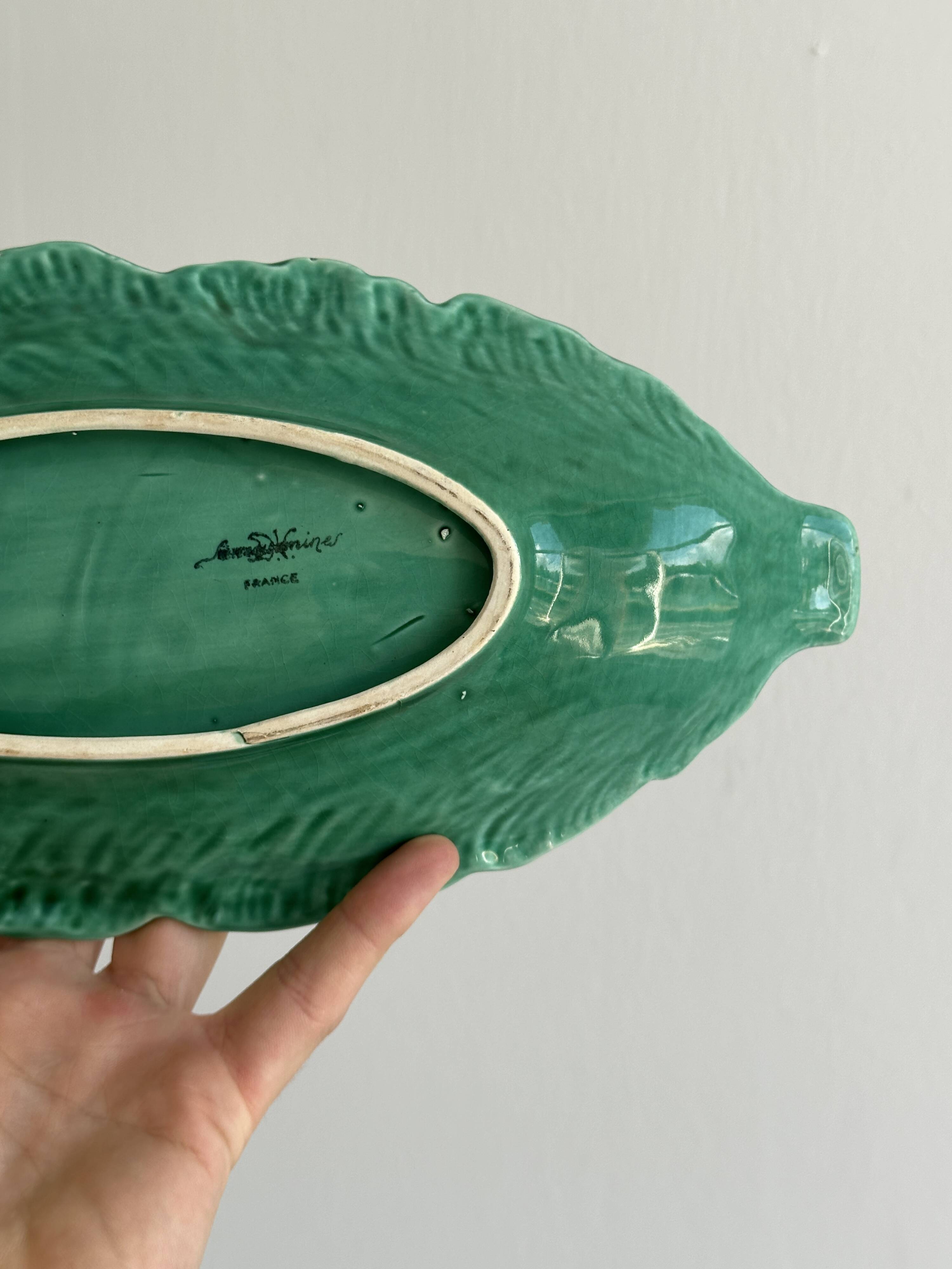 Green earthenware dish in the shape of a leaf