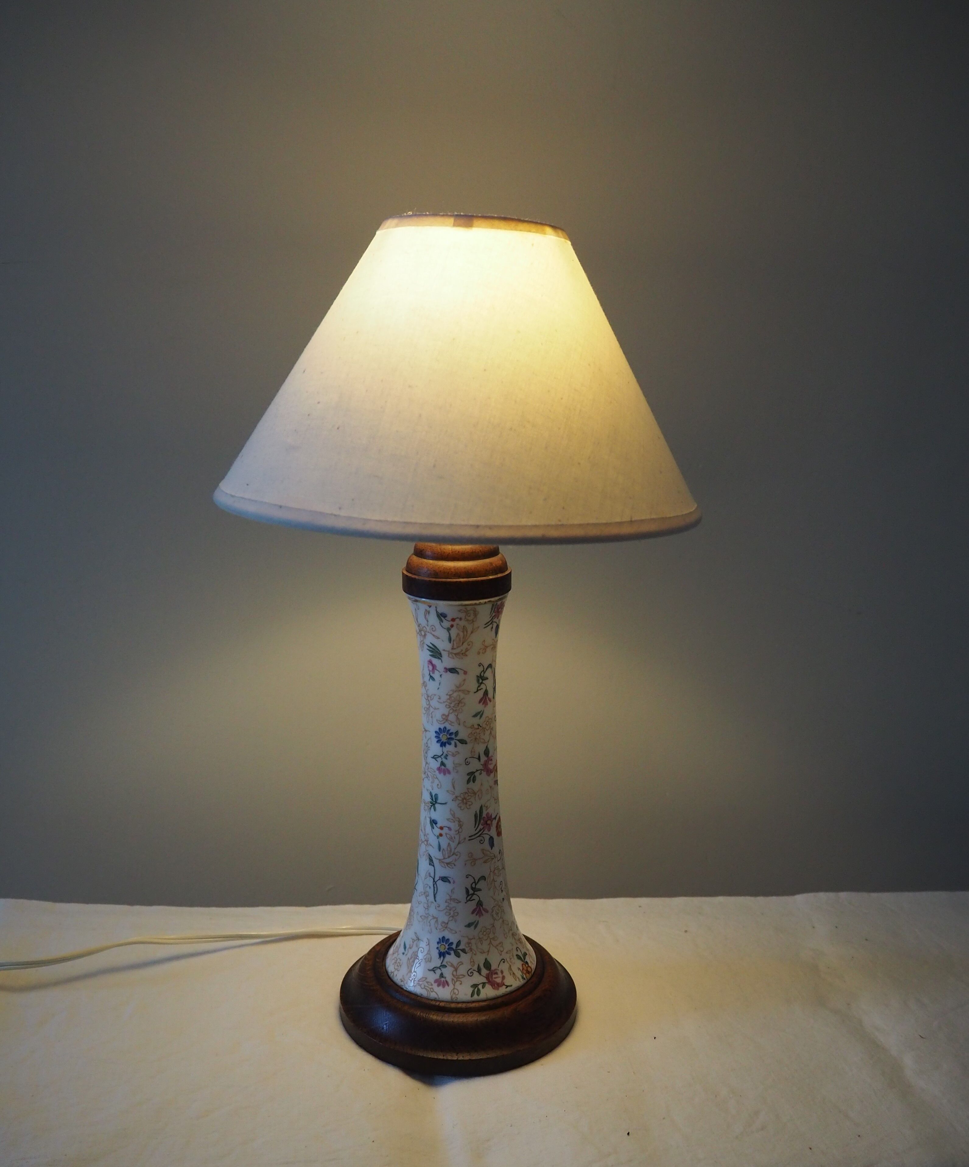 Table lamp for bedside use in earthenware with a wooden base.