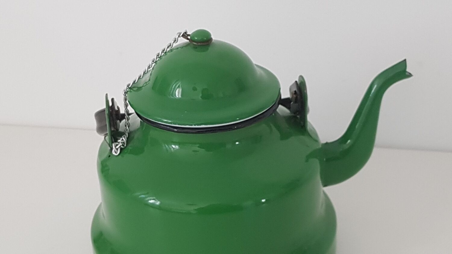 Old green kettle in enamelled metal