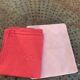 Duo set, consisting of two large pink-dyed cotton and linen towels, embroidered, TK monograms