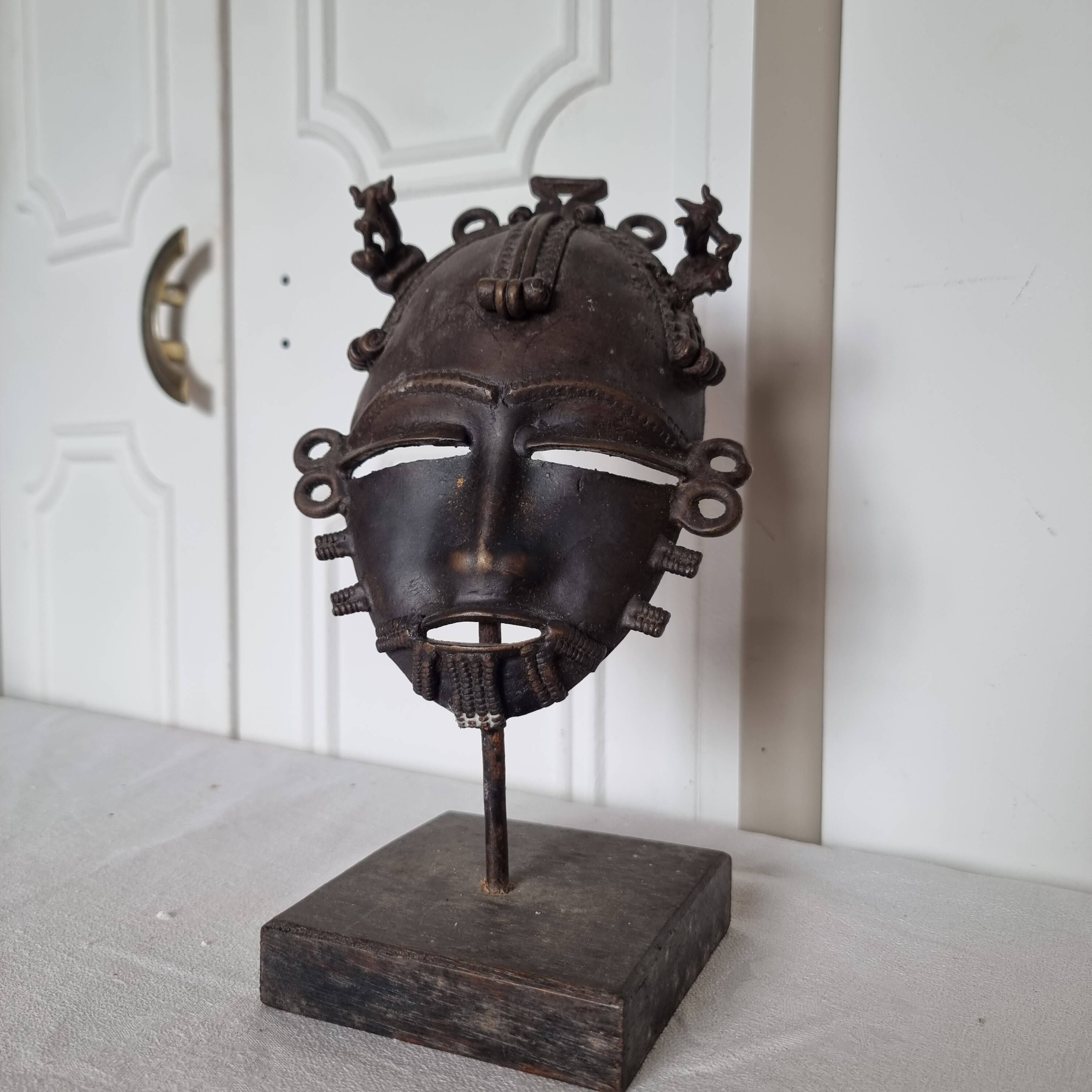 African bronze mask on pedestal, from Ivory Coast, dating